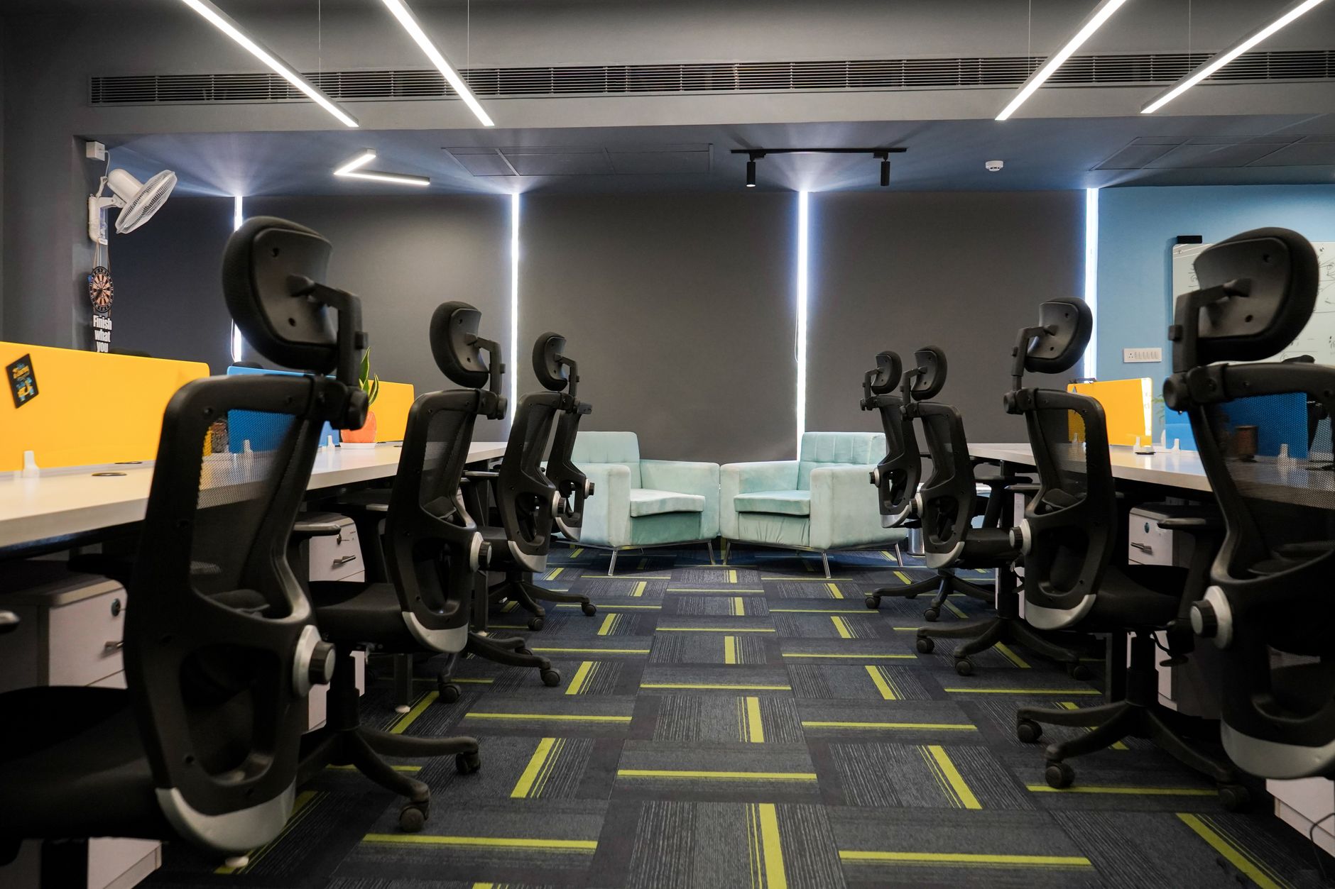 Sala de escritorios vacía con sillas y luz de techo